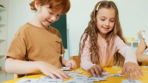 Happy children engaged in learning with educational flashcards in a classroom setting.